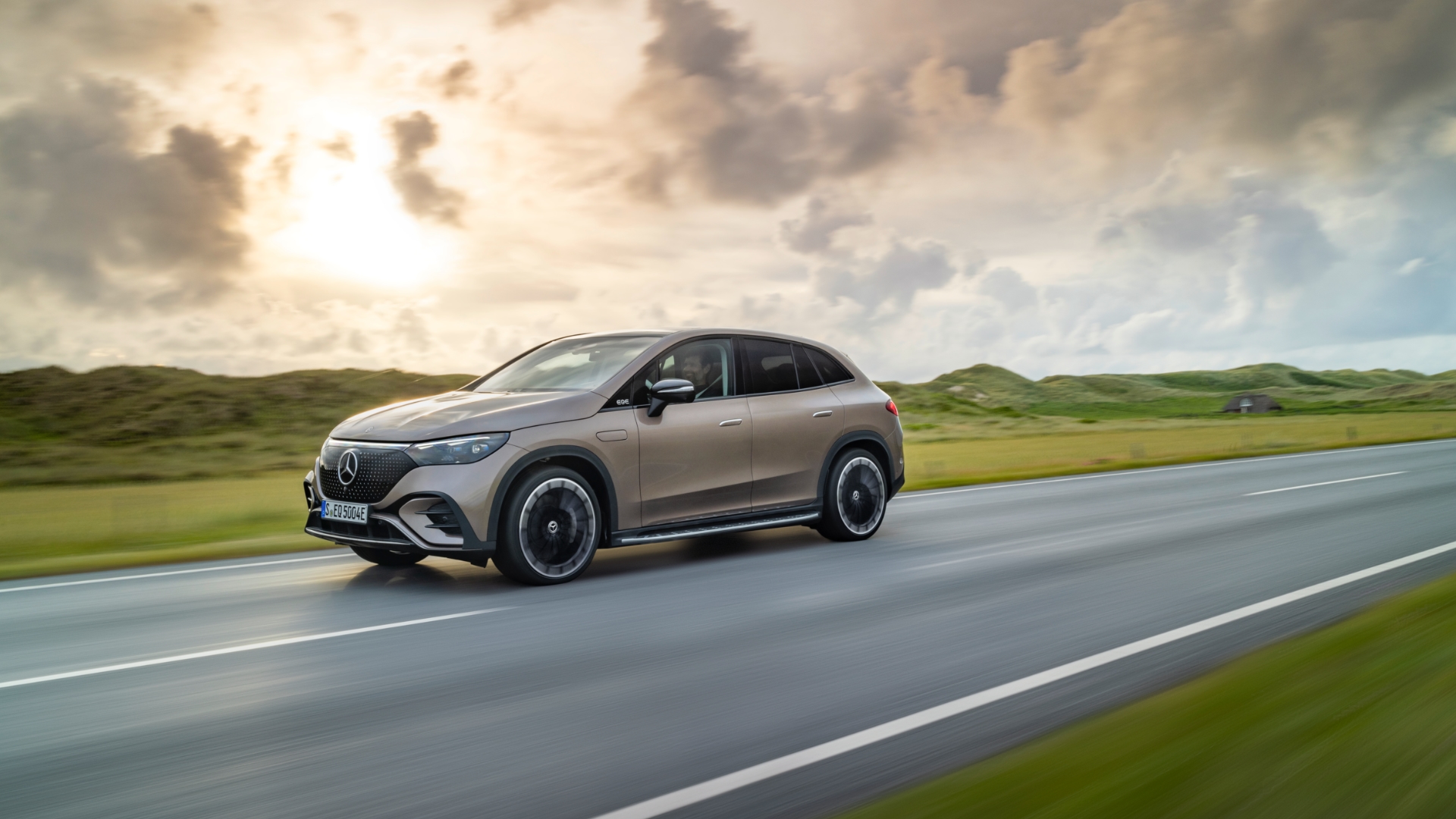 Driving shot of Mercedes Benz EQE SUV with sunset backdrop