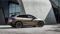 Static shot of Mercedes Benz EQE SUV with concrete pillar and glass building in background