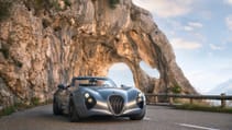 Static shot of Weismann Thunderbolt on mountainous road, which cuts through rock tunnel
