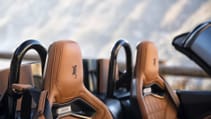 Ground angled shot of driving seats, embossed headrests of Weismann Thunderbolt