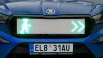 Close up of a Skoda Enyaq grille with LED light system for pedestrians, depicting green man and green arrow