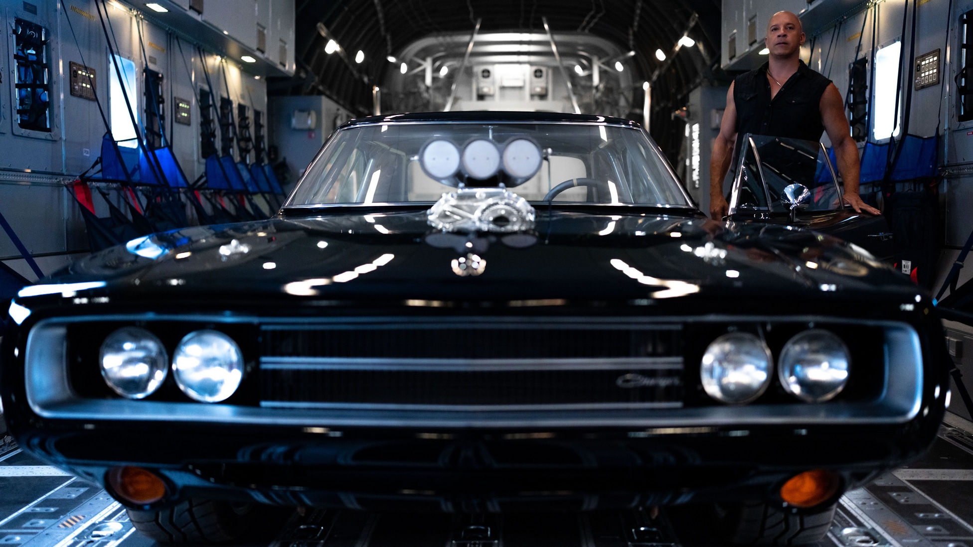 Dominic Toretto, interpretado por Vin Diesel, ao lado de um Dodge Charger preto em Velozes e Furiosos 10