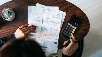 Someone working out their finances on a calculator
