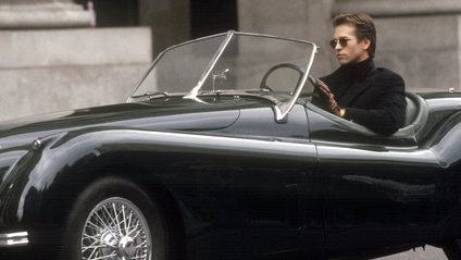 Val Kilmer as Bruce Wayne in a black 1953 Jaguar XK120 roadster, as featured in the 1995 movie Batman Forever