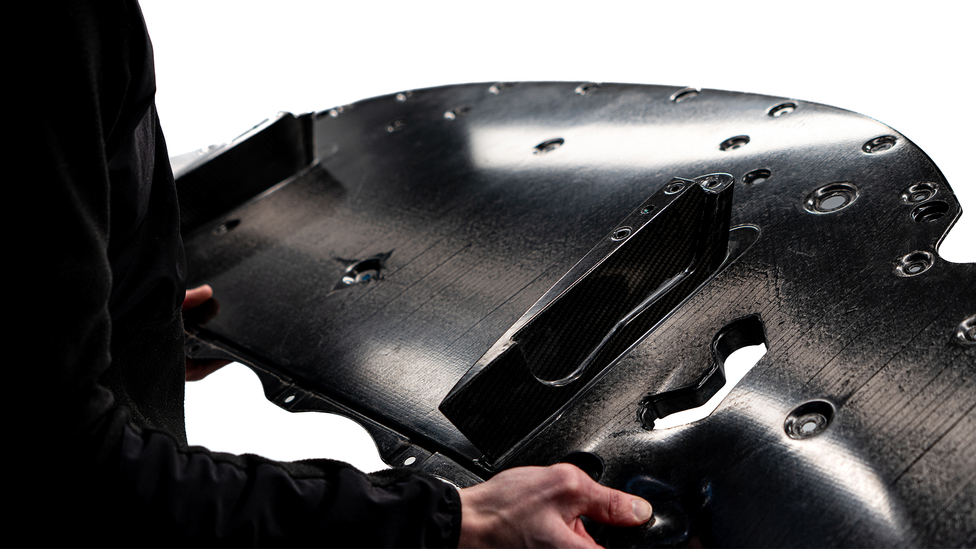 Man in black jumper holding carbon fibre panel