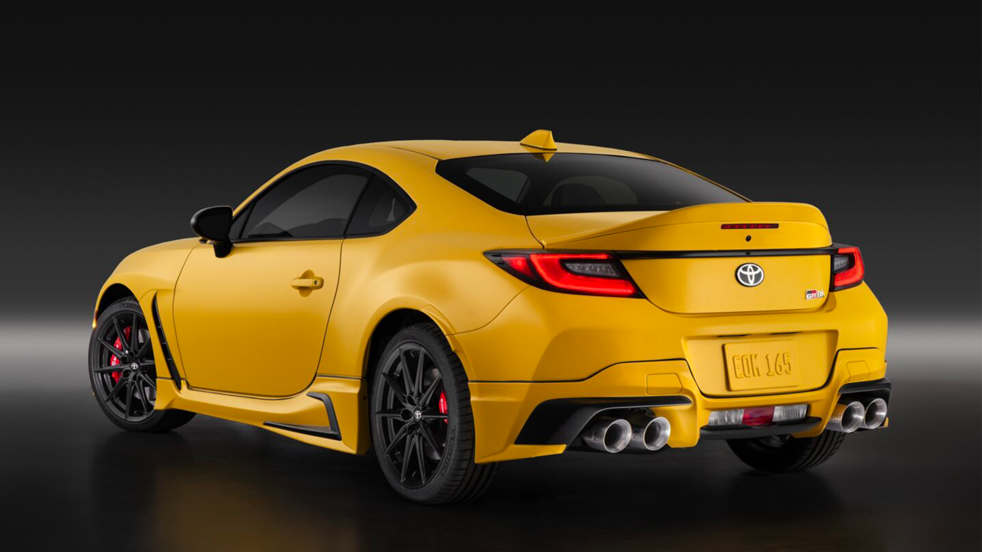 Rear three-quarter static shot of Toyota GR86 Yuzu Edition, a bright yellow sports car