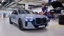 Static shot of BMW i7 with ASSBs fitted with colleagues discussing analysis in workshop, front three quarter