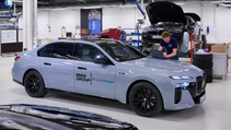 Static shot of BMW i7 with ASSBs fitted with colleagues discussing analysis in workshop