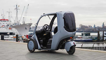 Static shot of the Hopper e-Bike (covered trike) with a harbour backdrop