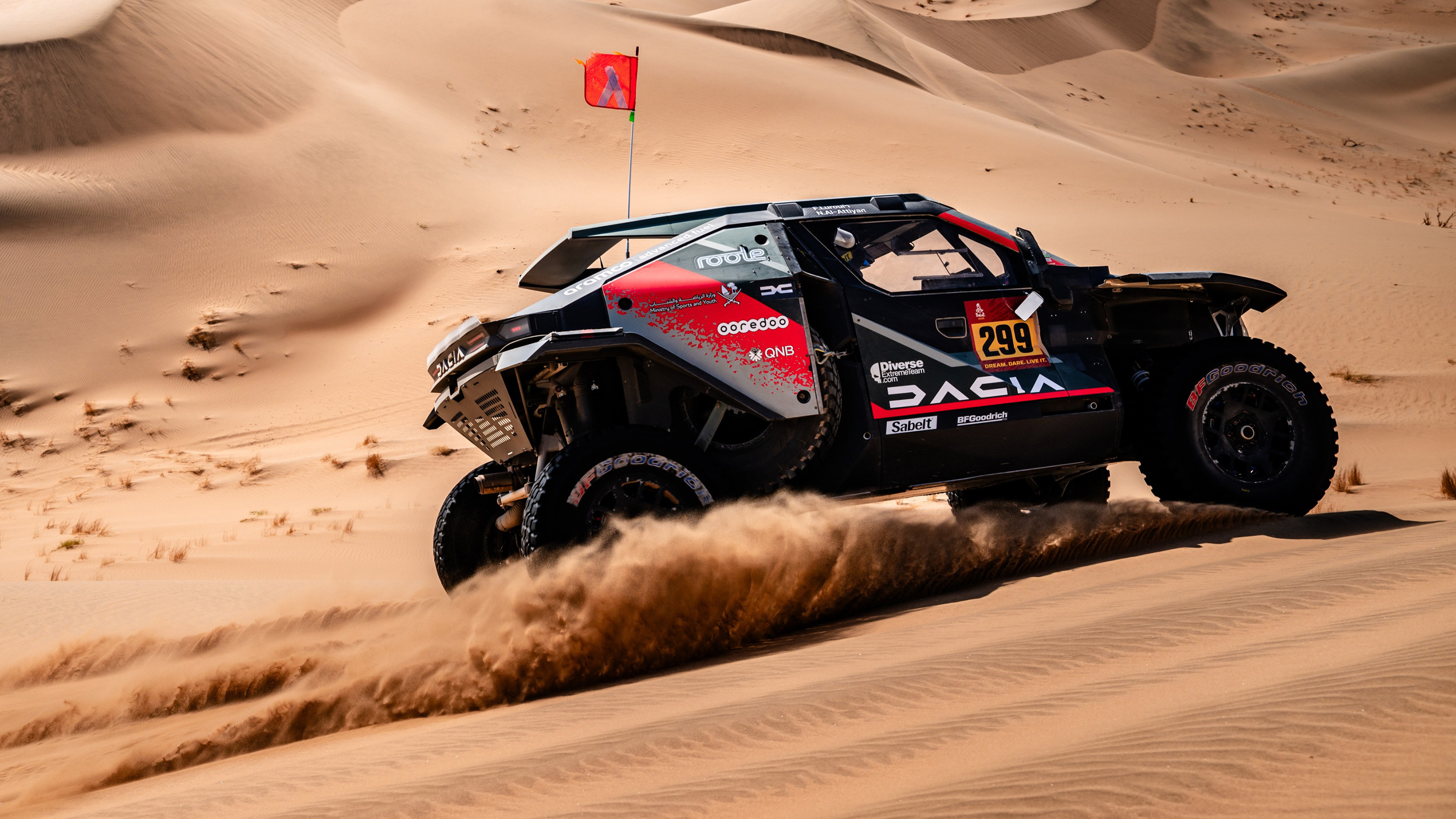 Dacia Dakar Rally car racing on a sand dune