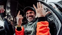 Dacia Dakar Rally driver pictured inside car holding up 6 fingers.