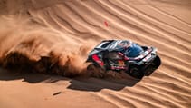 Dacia Dakar Rally car racing across a sand dune