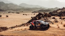 Dacia Dakar Rally car racing across a sand dune