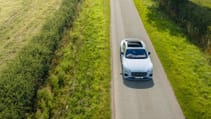 Bentley Continental GT Mulliner driving along a rural road.