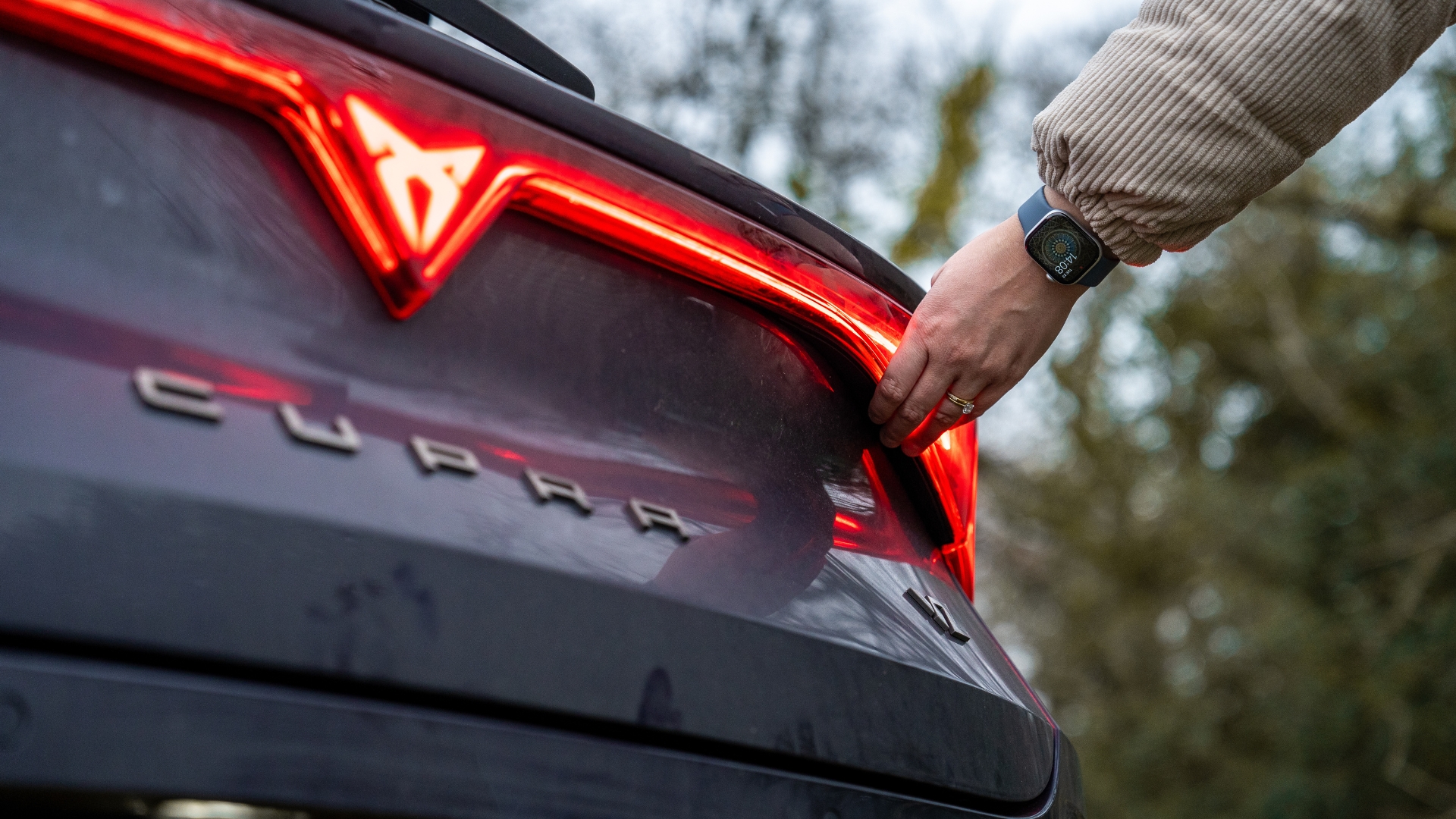 Close up of driver about to open Cupra Leon Estate VZ1 boot