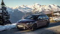 Cupra Leon Estate VZ1 parked on a mountainous road with a mountain ranges and snow in the background