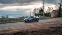Cupra Leon Estate VZ1 driving through a rural area with a slightly blurry background
