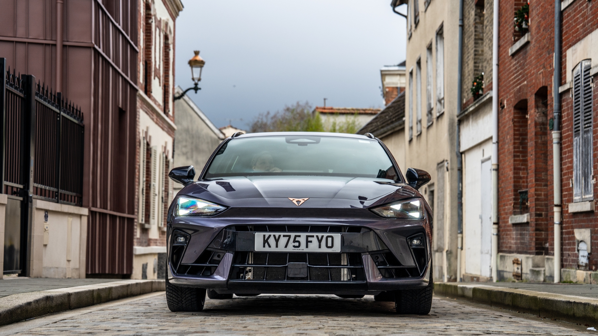 Cupra Leon Estate VZ1 driving through a small town, pictured from the front.