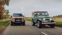 Two Toyota Land Cruisers driving along a road