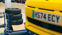 A close up of yellow Renault 5 car is in a garage.