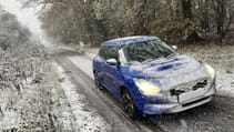 Blue Suzuki Swift covered in snow