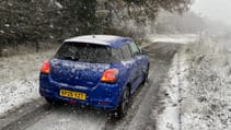 Blue Suzuki Swift covered in snow