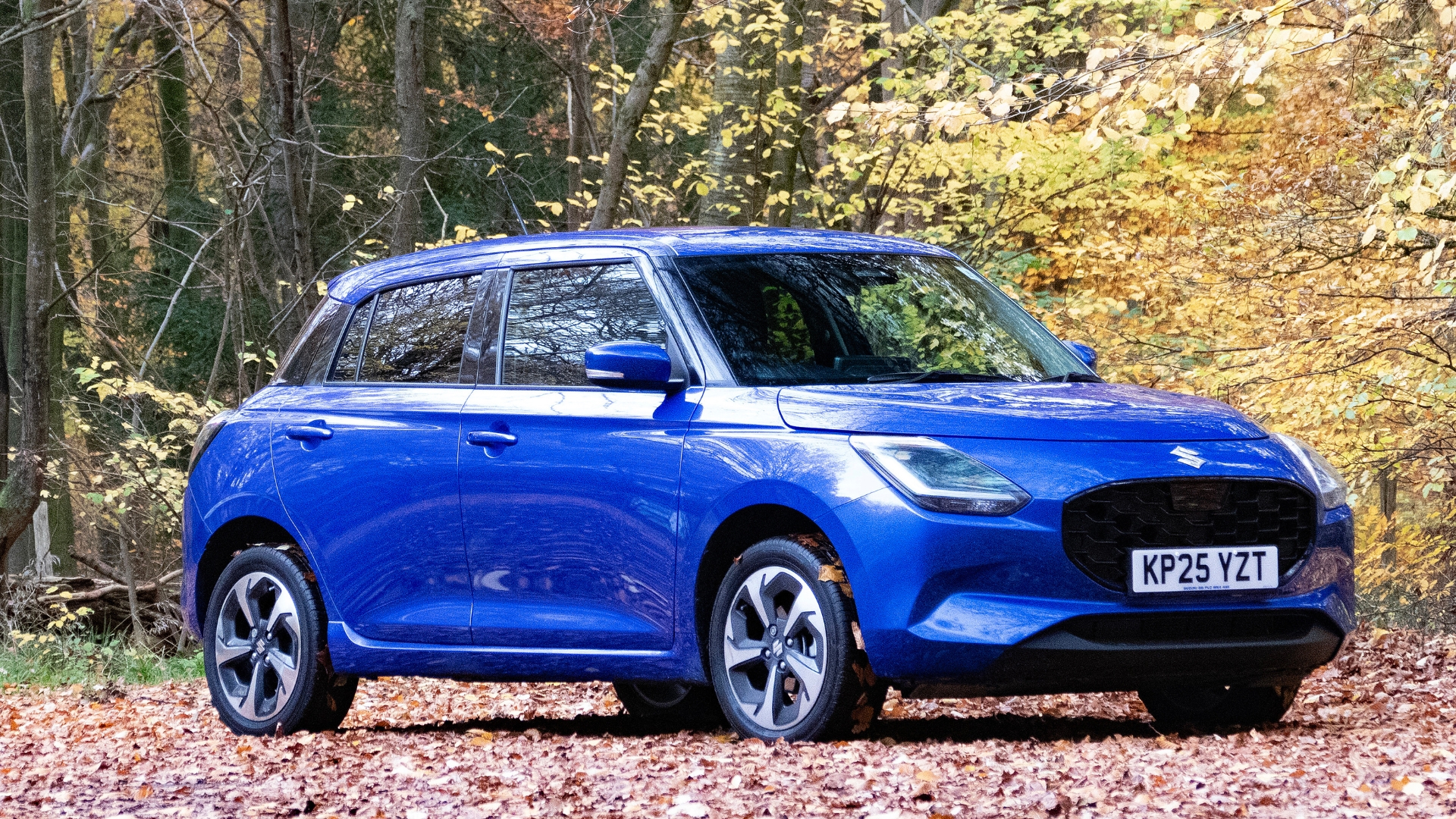 Suzuki Swift parked outside on a leafy round.
