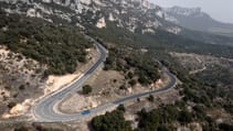 Wide shot of a Aston Martin Valhalla driving on a windy road