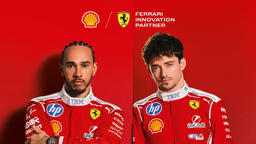 Lewis Hamilton and Charles Leclerc pose confidently in red Ferrari Formula 1 suits against a bold red backdrop with Shell and Ferrari logos