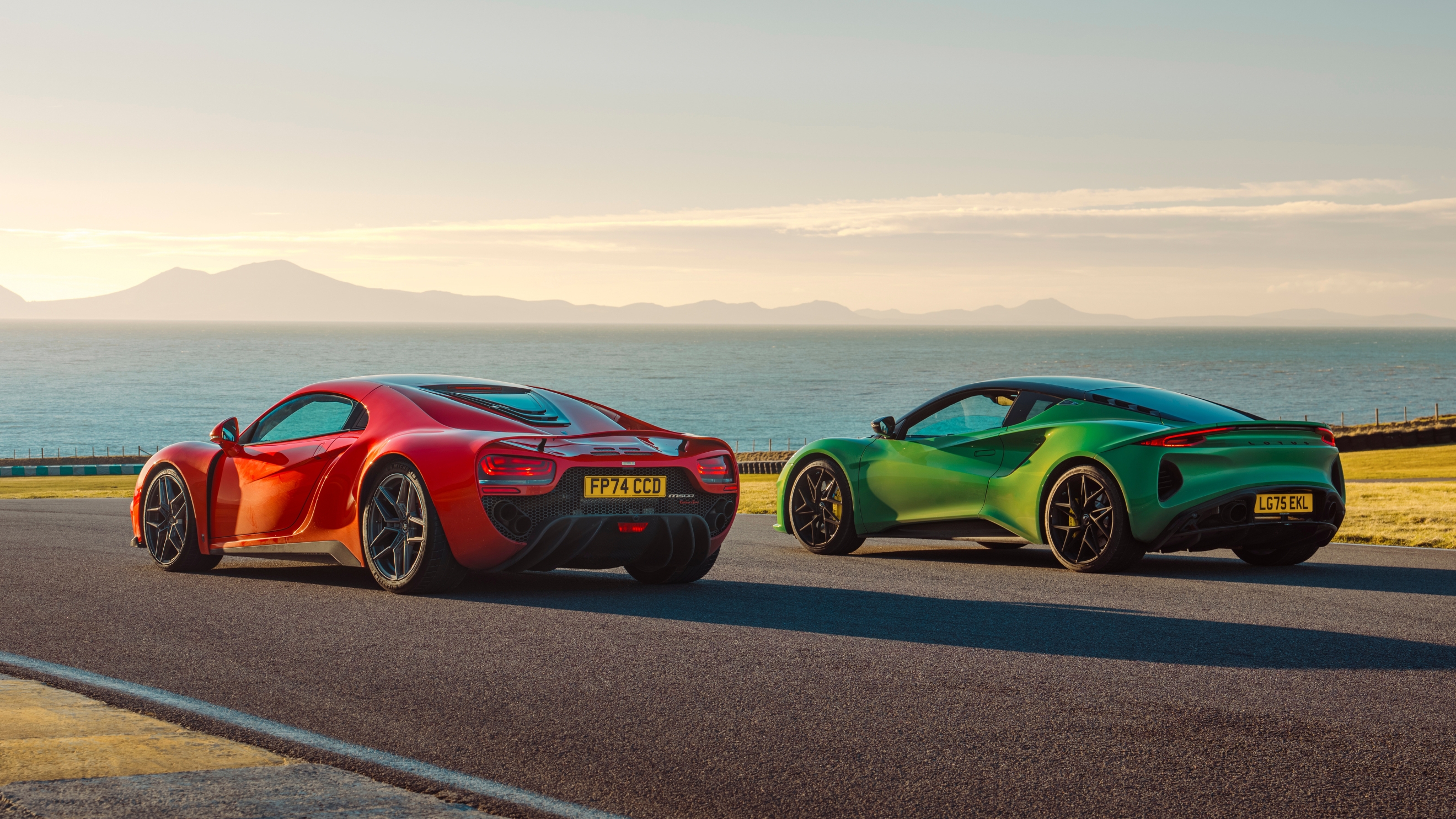 Noble M500 and Lotus Emira parked next to each other, pictured from the back