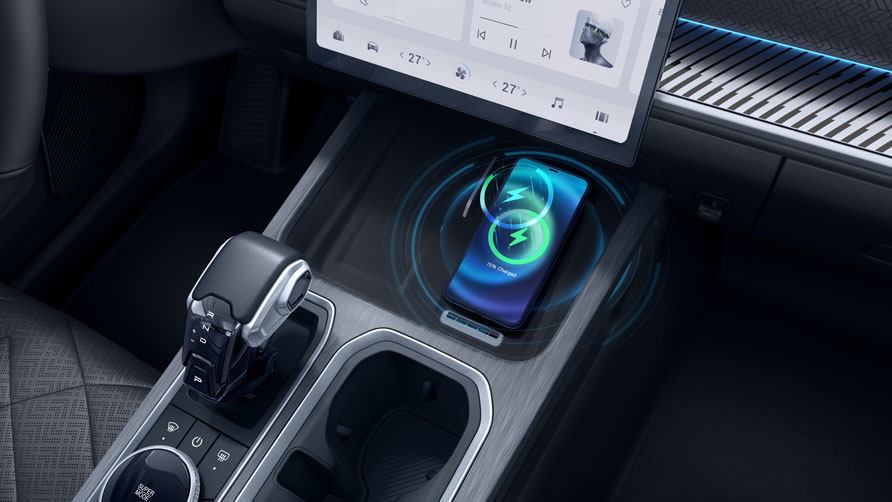 Close-up of of the hybrid JAECOO 7's center console featuring a wireless charging pad with a smartphone displaying 50% charge. Modern, sleek interior design