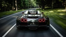 Bugatti Veyron driving on a quiet country road lined with tall trees, pictured from behind