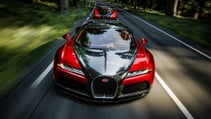 Bugatti Veyron driving on a quiet country road lined with tall trees, pictured from the front