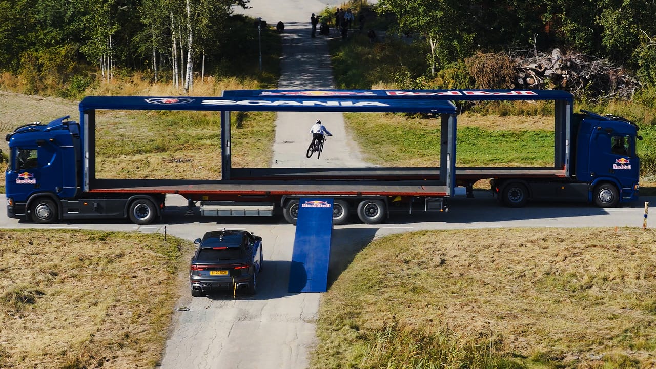 Mountain biker jumps between self-driving trucks