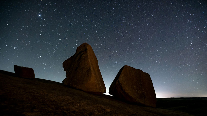 A clear night sky adorned with stars over striking rock formations in Fredericksburg, Texas Hill Country
