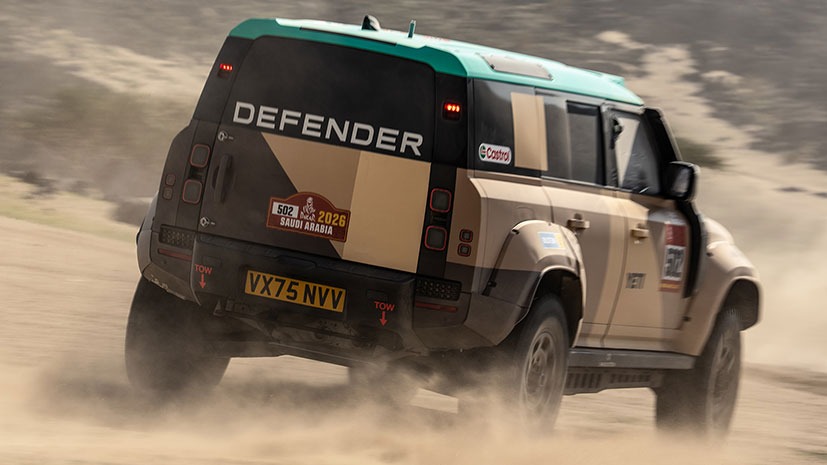 A rugged An off-road Land Rover Defender Dakar D7XR vehicle speeds through a desert track at the 2026 Saudi Arabia even