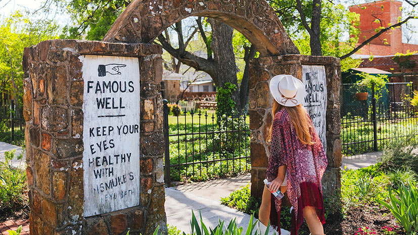 A woman strolls along a path in the renowned Mineral Water Co. garden in Mineral Wells, Texas