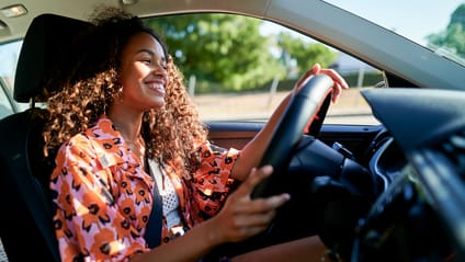 Someone smiling while driving a car 