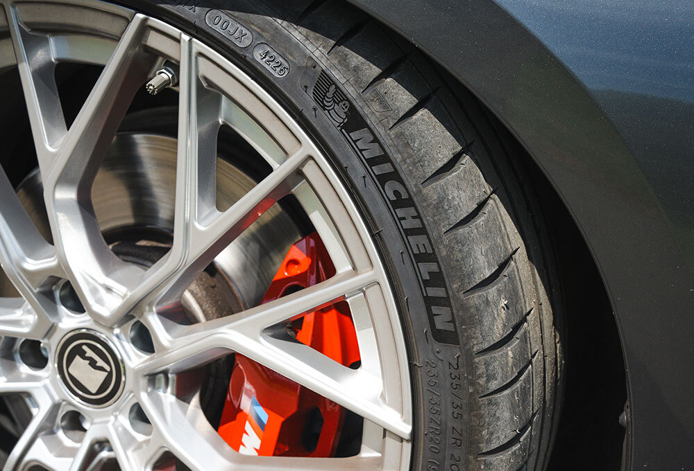 A close-up of a MICHELIN Pilot Sport 4 S tyre on a black 2022 BMW 330D Touring